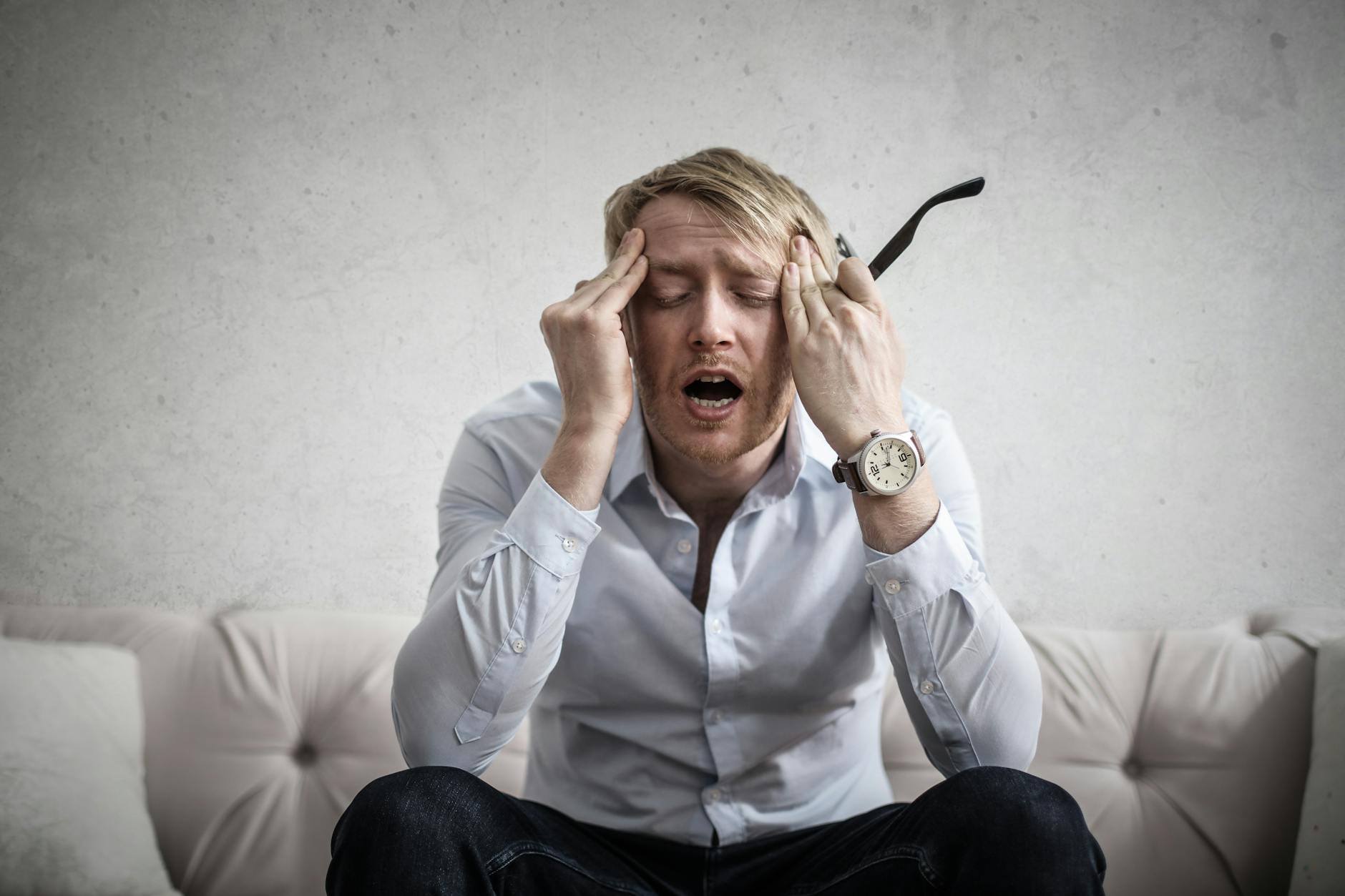 photo of man touching his head